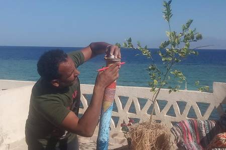 Installation d'un système de surveillance du microclimat du jardin. Un ensemble complet de capteurs numériques assemblé au sein d’un boîtier en bambou décoré d’une œuvre originale. Mer Rouge, Golfe d’Aqaba, janvier 2024